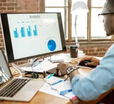 A futuristic AI-powered workspace where an entrepreneur analyzes business growth trends on a digital dashboard.