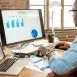 A futuristic AI-powered workspace where an entrepreneur analyzes business growth trends on a digital dashboard.